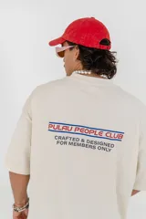 Remera color crema de corte holgado con estampado en la espalda que dice 'Pulau People Club Crafted & Designed For Members Only'.