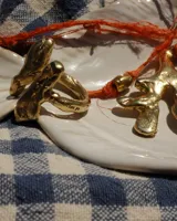 Anillo de diseño orgánico y macizo, realizado artesanalmente en bronce. Presenta una estructura abierta con dos piezas de forma irregular y textura rugosa.
