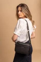 Bandolera color mostaza de simil cuero, con tres cierres principales, cierre delantero y bolsillo trasero. Incluye correa ajustable.