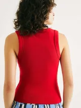 Musculosa negra de tela acanalada, con escote redondo pronunciado (cuello U) y corte ajustado al cuerpo.