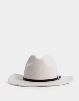 Sombrero fedora color crudo con cinta decorativa de cuero sintético negro y hebilla metálica plateada.