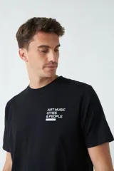 Remera negra de algodón con estampado en la espalda con la frase "ART MUSIC CITIES & PEOPLE".