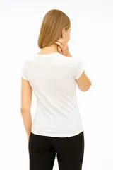 Blusa blanca de algodón con cuello a la base y mangas cortas.