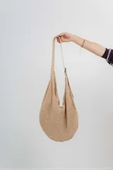 Bolso tejido color beige con correa regulable de ecocuero.
