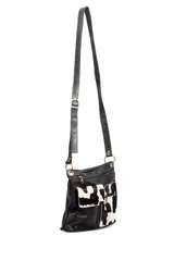 Morral bandolera de cuero negro con dos bolsillos frontales de cuero con estampado animal print de vaca.
