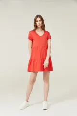 Vestido corto lila con cuello en V y mangas cortas. Tiene corte holgado y dos volados en la falda.