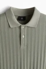 Remera polo verde salvia de punto texturizado, corte slim fit, manga corta, cuello clásico y tapeta con dos botones.