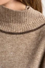 Sweater negro de tejido grueso con cuello alto acanalado. Presenta una franja decorativa en las mangas y el cuello en hilo marrón con brillo (lurex).