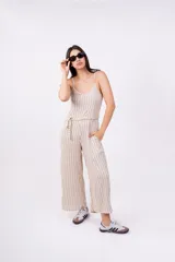 Mono largo color beige con rayas verticales negras, breteles finos, escote en V y lazo en la cintura.