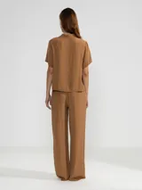 Pantalón palazzo color marrón, de corte recto y cintura elastizada.