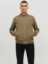 Campera bomber color verde militar, con cuello redondo, cierre frontal con cremallera, bolsillos laterales con cremallera y bolsillo en la manga izquierda con cremallera.