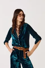 Camisa de manga larga, color verde azulado (teal), confeccionada en terciopelo de seda y viscosa. Presenta cuello camisero clásico y botones de nácar. El corte es ligeramente más largo en la espalda.