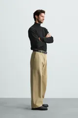 Jersey negro de punto fino con cuello alto y manga larga.