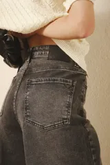 Jean oxford tiro alto de denim negro con lavado stone y bigotes. Pierna ancha desde la cadera.