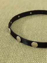 Cinturón negro de cuero vacuno con apliques metálicos plateados y hebilla metálica con diseño exclusivo.