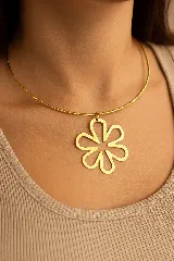 Gargantilla dorada con dije de flor calada.