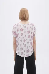 Remera blanca con estampado floral en color lila, de corte holgado y mangas cortas.
