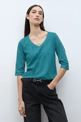Remera verde petróleo con escote en V, mangas tres cuartos y diseño de broderie calado.