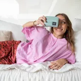 Billetera corta con cierre alrededor y tapa, confeccionada en tela capitoneada. Incluye varias reparticiones con tarjeteros y bolsillos internos, y una correa de mano desmontable. Disponible en negro, rojo y dorado.