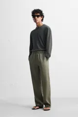 Pantalón negro regular fit confeccionado en tejido de lino. Cintura ajustable con cordón interior, bolsillos frontales y detalle de bolsillos traseros de vivo.