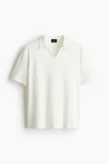 Remera blanca de punto texturizado con cuello y miniabertura en V.