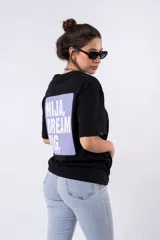 Remera negra de corte oversize con estampado frontal que dice "MIJA DREAM BIG" en tipografía blanca y rosa.