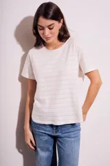 Remera blanca de algodón texturizado con cuello redondo y mangas cortas.