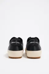 Zapatillas deportivas bajas con estampado animal print, puntera y suela de goma negra y cordones negros.