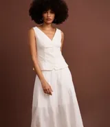 Pollera midi de corte evasé confeccionada en sarga de algodón blanco. Presenta un diseño con recortes verticales y nesgas que aportan volumen en el ruedo, cintura ajustada y largo por debajo de la rodilla.