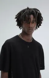 Remera negra de tejido de punto con moldería oversize, confeccionada en viscosa y poliéster. Presenta un diseño de malla con pequeños agujeros y un dobladillo acanalado.