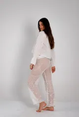 Pantalón largo de crochet color blanco, con diseño calado y corte acampanado.