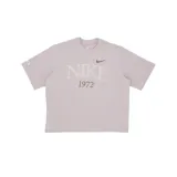 Remera color lila claro de algodón, con cuello redondo y mangas cortas. Estampado frontal con el logo de Nike y el año 1972 en color marrón.