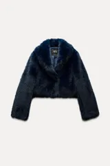 Abrigo corto azul marino de piel sintética, con cuello solapa y manga larga. Tiene bolsillos laterales ocultos en la costura, forro interior combinado y cierre frontal con gancho metálico forrado.