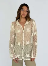 Camisa beige de crochet con diseño de flores, cuello clásico y cierre frontal con botones.