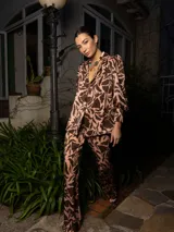 Conjunto estampado con hojas abstractas en tonos marrón y rosa, compuesto por una camisa de manga larga con puños anchos y un pantalón de corte recto.