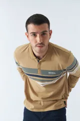 Remera cuello polo de manga larga color beige con rayas horizontales en verde, azul y blanco.