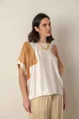 Blusa italiana color natural con estampado de hojas grandes en tonos marrones. Tiene cuello redondo y mangas cortas amplias.