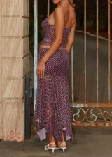 Conjunto de top y falda midi color borgoña con estampado de lunares blancos. El top es de tirantes finos y la falda tiene volantes en el ruedo.