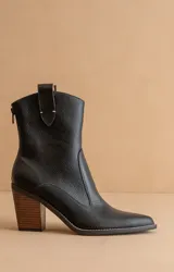 Botín negro de cuero sintético con puntera fina, caña media y tacón de madera.