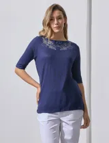 Remera verde con escote redondo y mangas tres cuartos. Presenta bordados en el escote.