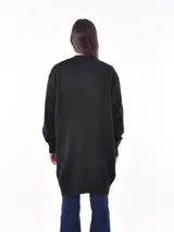 Saco color beige de tejido de punto, con mangas largas y corte holgado.