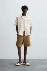 Camisa de manga corta con cuello bowling y corte relaxed fit, confeccionada en tejido con mezcla de algodón y estampado a cuadros.
