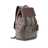 Mochila negra de tela canvas con detalles en símil cuero marrón, cierre superior marinero, bolsillos internos y externos con cierre metálico, asas rígidas y correas ajustables.