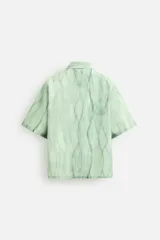 Camisa verde agua con estampado abstracto, corte relaxed fit, cuello solapa, manga corta y cierre frontal con botones.