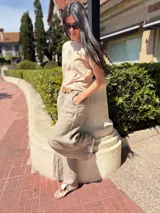 Pantalón marrón de lino con bordados blancos en los laterales y bolsillos. Corte recto y cintura con elástico.