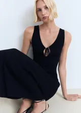 Vestido midi negro de punto, con escote en V y detalle de lazo en el centro del busto.