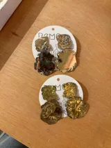 Aros colgantes de bronce con forma irregular y textura rugosa.