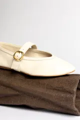 Ballerinas negras de cuero con tira sobre el empeine y hebilla dorada.