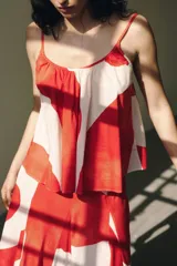 Top blanco con estampado de círculos rojos, escote redondo, breteles finos y corte evasé.