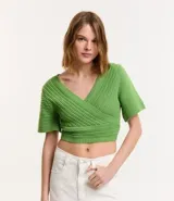 Blusa cropped de punto color verde, con escote cruzado en V y mangas cortas.